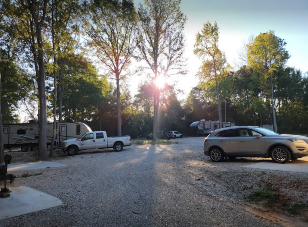 Sunrise over a full RV park with all sites occupied, warm morning light across RVs and concrete pads