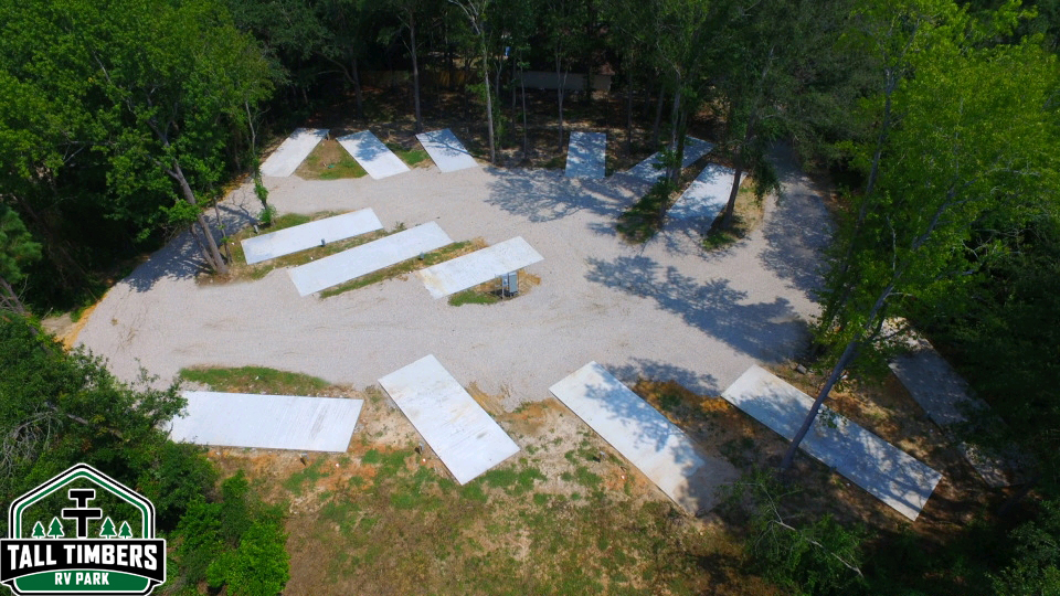 Far overhead view of RV park showing concrete pads arranged in a neat, efficient layout with full hookups